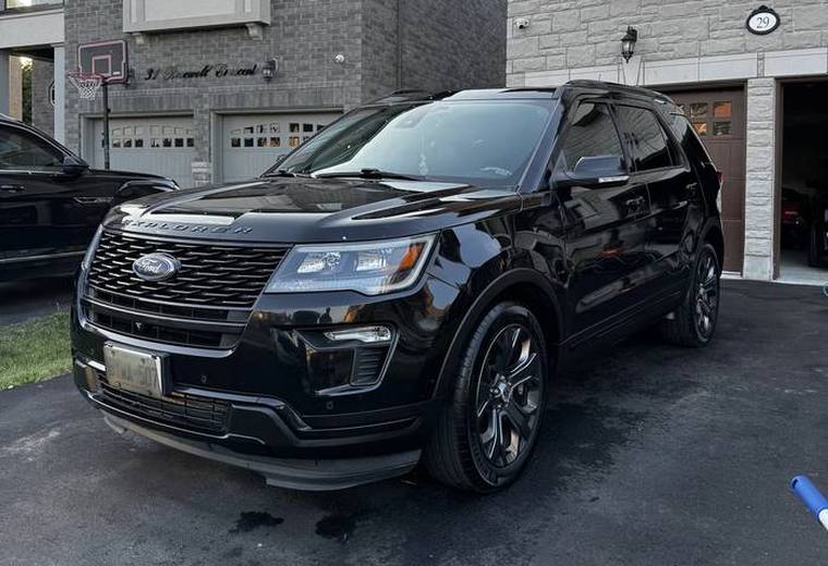 Black Ford Explorer in driveway, glossy paint and alloy wheels