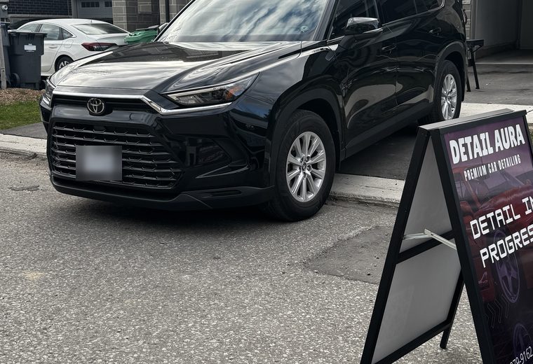 Black Toyota Grand Highlander finished beside a Detail Aura sign