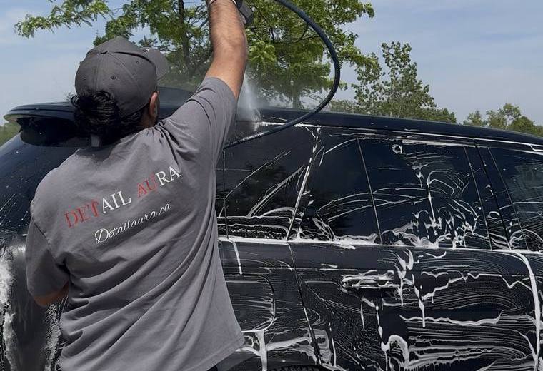 Detail Aura staff pressure washing foam from black SUV