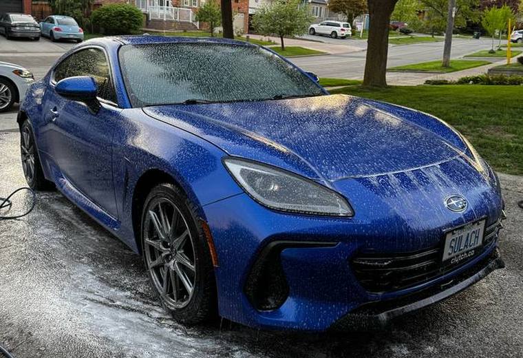 Blue Subaru BRZ with water beading across wet paint